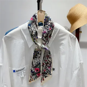 Detail of multi-color floral twilly scarf tied on a white shirt with brand tags