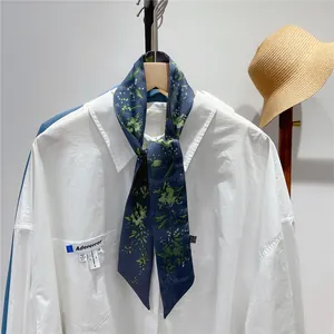 Floral print navy twilly scarf tied on a white shirt neck for elegant French style styling