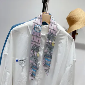 Floral print silk scarf styled as a neck tie on a white shirt with tropical patterns