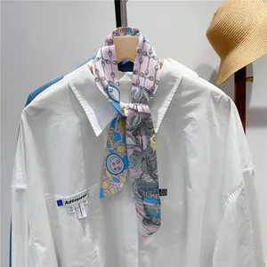 Detailed view of pink floral twilly scarf tied on a white shirt collar for summer styling