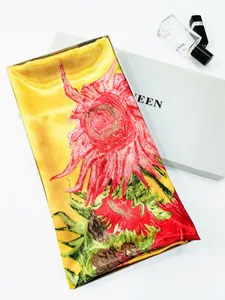 Détail du foulard en soie imprimé tournesols de Van Gogh plié dans un coffret cadeau chic