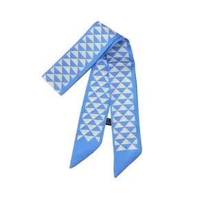 Détail d'un foulard twilly en soie bleu clair avec des triangles blancs et pointes biaises