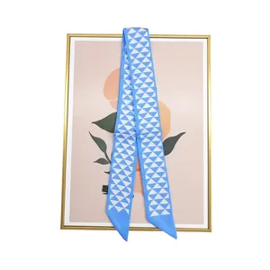 Gros plan du foulard en soie bleu ciel à motifs géométriques et finitions en pointe nette