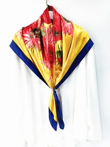 Détail d'un foulard en soie à imprimé tournesol avec boucle sur un col de chemise blanc