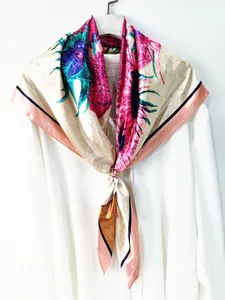 Détail d'un foulard en soie à fleurs avec boucle dorée sur une chemise blanche