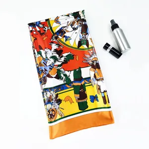 Macro detail of silk scarf featuring equestrian prints and orange hand-rolled edges