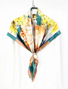 Detail of artistic floral pattern scarf showing vibrant orange, yellow and green silk texture
