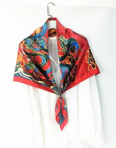 Close-up of red silk scarf with Dunhuang patterns styled on a white shirt