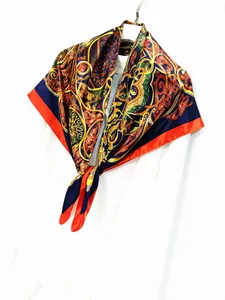 Close-up of vintage Baroque pattern silk scarf with red border on white hanger
