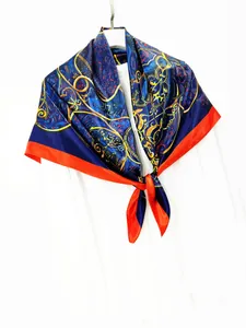 Detail of vintage navy blue silk scarf with golden baroque pattern and orange edges