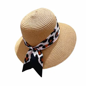 Flat top straw sun hat with leopard print ribbon bow for elegant summer beach styling