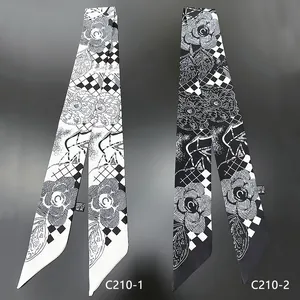 Primo piano dettagliato di due foulard twilly con motivo floreale di camelia in bianco e nero