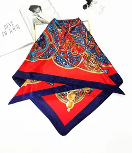 Close-up of vintage silk scarf with golden scroll patterns and red decorative borders