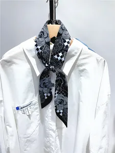 Dettaglio della cravatta con motivi floreali e scacchi su camicia bianca a maniche lunghe