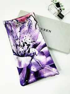Detail of floral purple silk scarf with satin luster neatly folded on a premium silver gift box