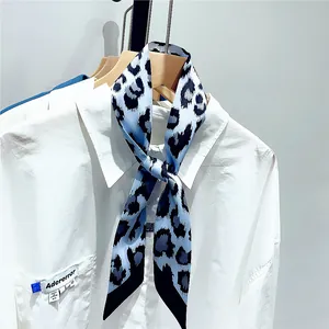 Detail showing blue leopard print necktie scarf styled on a white shirt collar