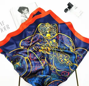 Detailed flat lay of blue silk square scarf with baroque patterns and orange border