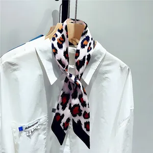 Pink leopard print skinny scarf styled as a necktie on a white shirt collar detail
