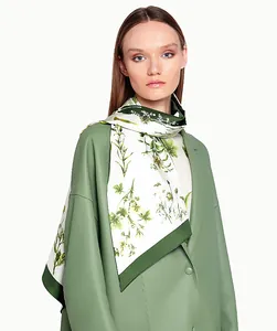 Détail d'un foulard en soie à imprimé floral vert porté sur une veste en cuir sauge