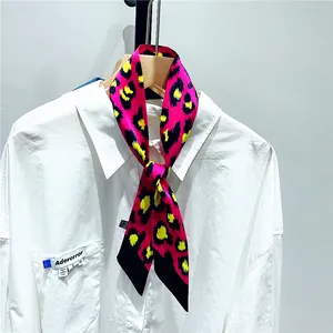Leopard print twilly scarf with pink and yellow tones styled on a white shirt collar