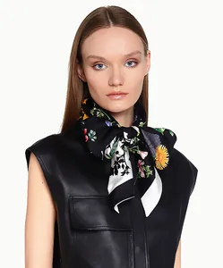 Gros plan d'un foulard en soie à imprimé floral double couche noué avec élégance au cou