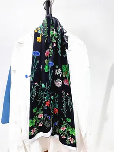 Détail d'une écharpe florale double épaisseur avec motifs botaniques sur satin noir