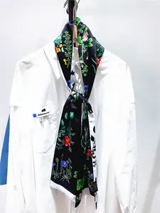 Détail d'un foulard en soie à imprimé floral avec un design bicolore noir et blanc pour femme