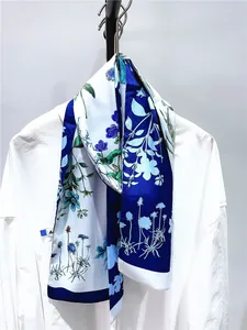 Détail d'un foulard en soie à imprimé floral bleu drapé sur un col de chemise blanc