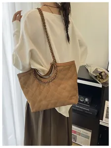 Detail of quilted camel tote bag with elegant chain strap and high-quality texture