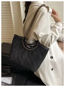 Détail du sac cabas matelassé noir avec texture mate et bandoulière chaîne