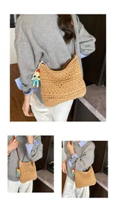 Detail of hollow-out crochet woven bag with brown leather strap and cartoon pendant