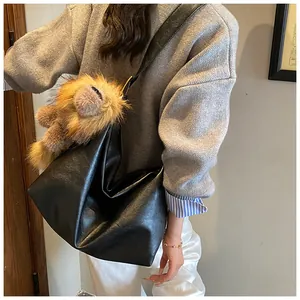 Dettaglio di borsa tote in ecopelle nera con un simpatico ciondolo a leone in peluche