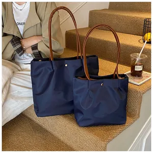 Deep blue waterproof nylon tote bag set showing large and small sizes with leather handles