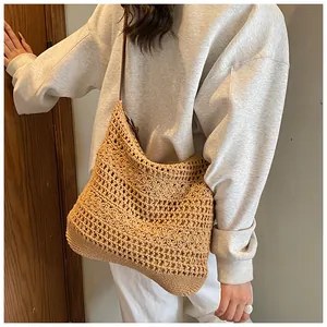 Close-up of bohemian hollow-out crochet woven shoulder bag in khaki with brown strap