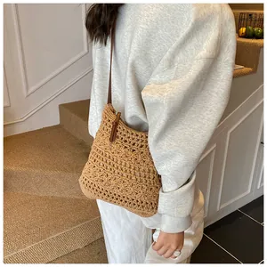 Detail of woven shoulder bag with floral hollow patterns and brown leather strap
