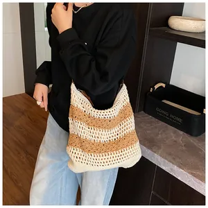 Detail of hand-crocheted striped tote bag with leather strap shown in a lifestyle setting