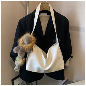 Dettaglio della borsa hobo in pelle bianca con un simpatico ciondolo a leone in peluche