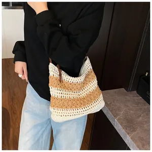 Close-up of handmade striped woven hobo bag showing crochet texture and dark shoulder strap