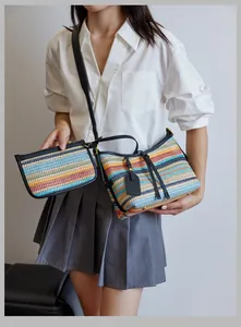 Detail view of colorful striped woven shoulder bag with matching pouch and leather strap