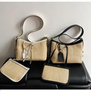 Detail of woven straw tote bag set with leather trim and matching mini zipper pouches