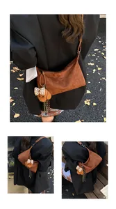 Detailed view of brown matte underarm bag with plush bear charm and plaid bow accent