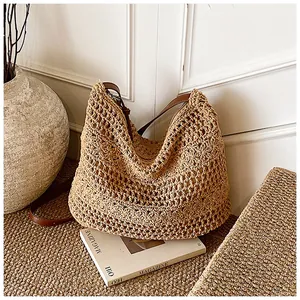 Detailed macro view of handcrafted woven texture and brown leather strap on a beige tote bag
