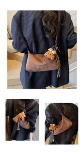 Detail view of brown faux suede shoulder bag with cute teddy bear charm accessory