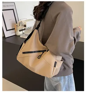 Detail of khaki crossbody bag featuring durable canvas and adjustable black strap on model