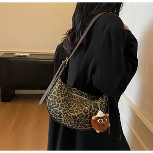 Detail der Canvas-Tasche mit Leopardenmuster und braunem Plüsch-Monster-Anhänger