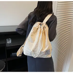 Dettaglio dello zaino in nylon impermeabile con coulisse e toppa con logo in tessuto