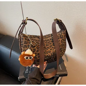 Detailansicht der Halbmond-Tasche mit Leopardenmuster, Plüsch-Anhänger und Ledergurt