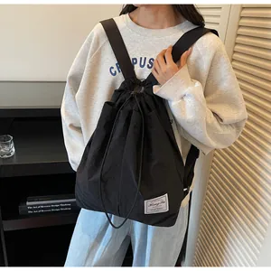 Dettaglio dello zaino in nylon nero idrorepellente con etichetta intrecciata del brand