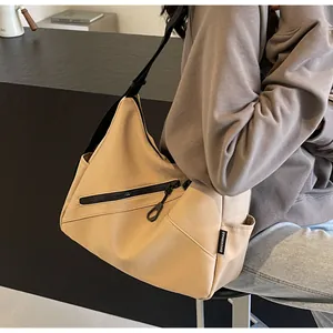 Close-up of the khaki canvas tote featuring a diagonal zipper pocket and wide black strap