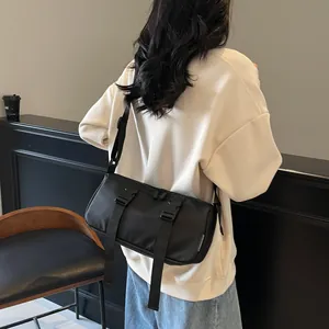 Schwarze Nylon-Umhängetasche mit Doppel-Steckschnallen und verstellbarem Gurt am Model